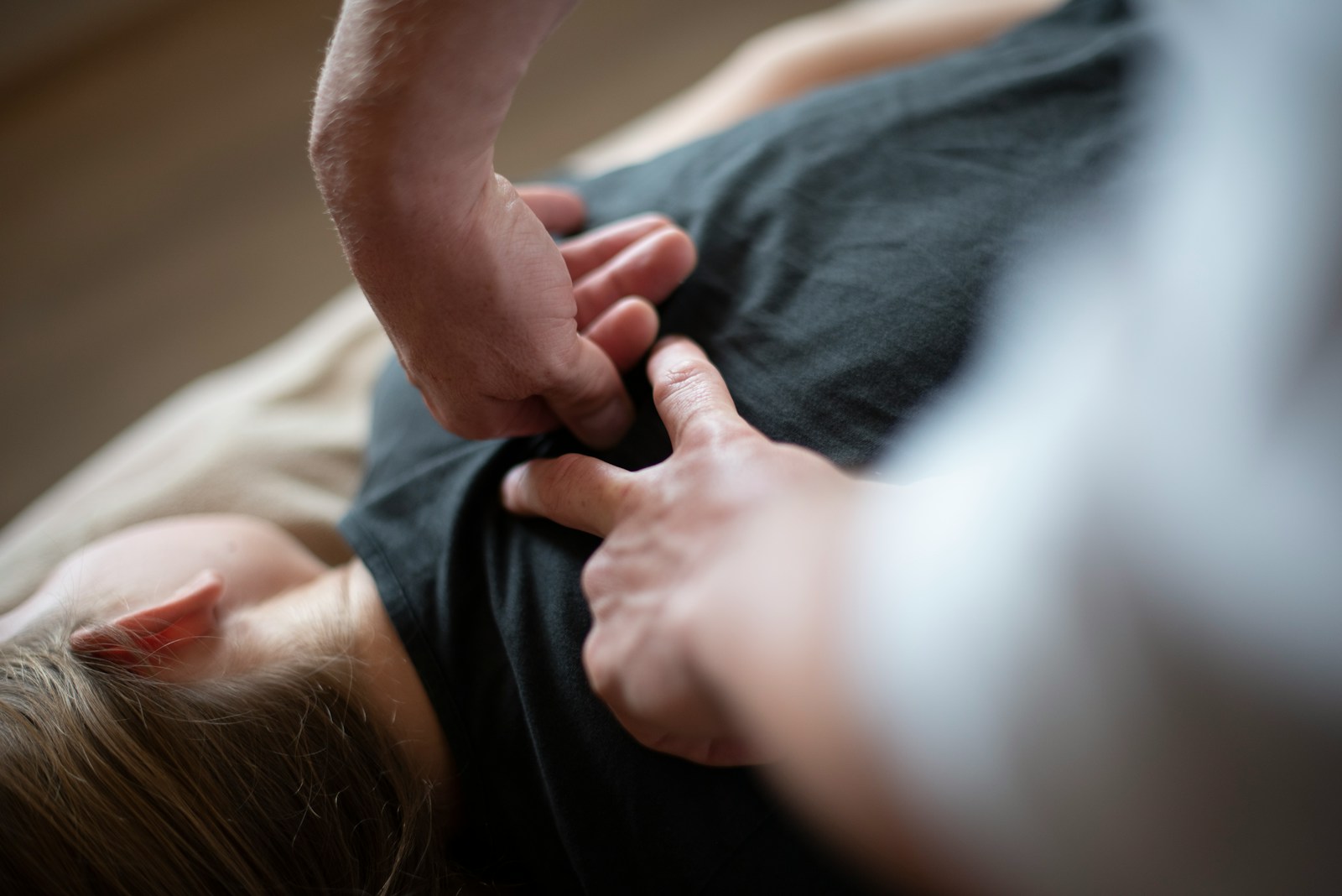 Hands pressing into the back of a person wearing a black shirt